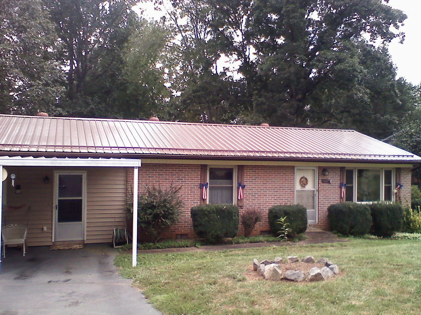 Bronze metal roof and carport on a brick ranch home — Roof Repair work by our crew in Cross Plains